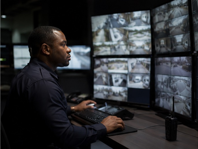 Security officer monitoring CCTV screens in a control room